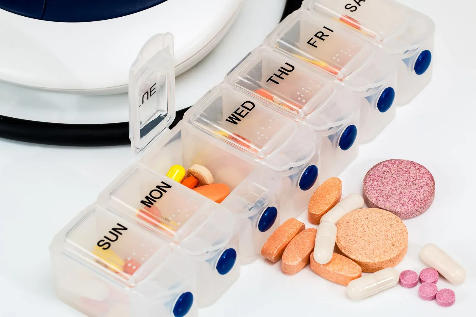 Symbolbild: Tablettenbox mit bunten Vitamintabletten und Kapseln